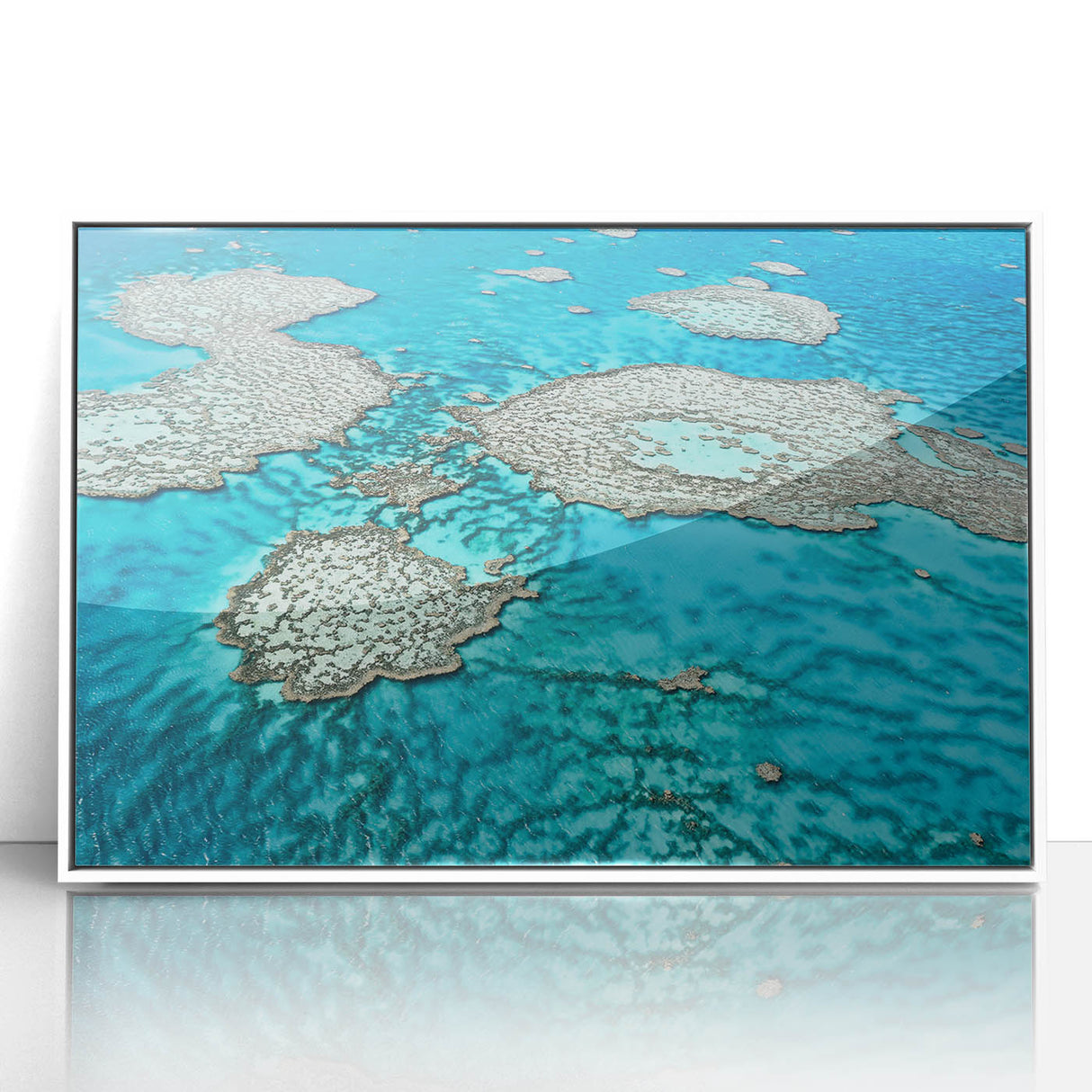 Large acrylic print of the Great Barrier Reef in soft blue and green tones, framed in white.
