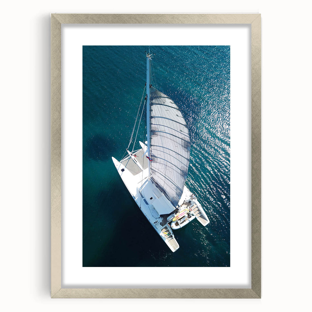 Abstract art print of a Caribbean scenery in muted green and blue tones, framed with a silver mat.