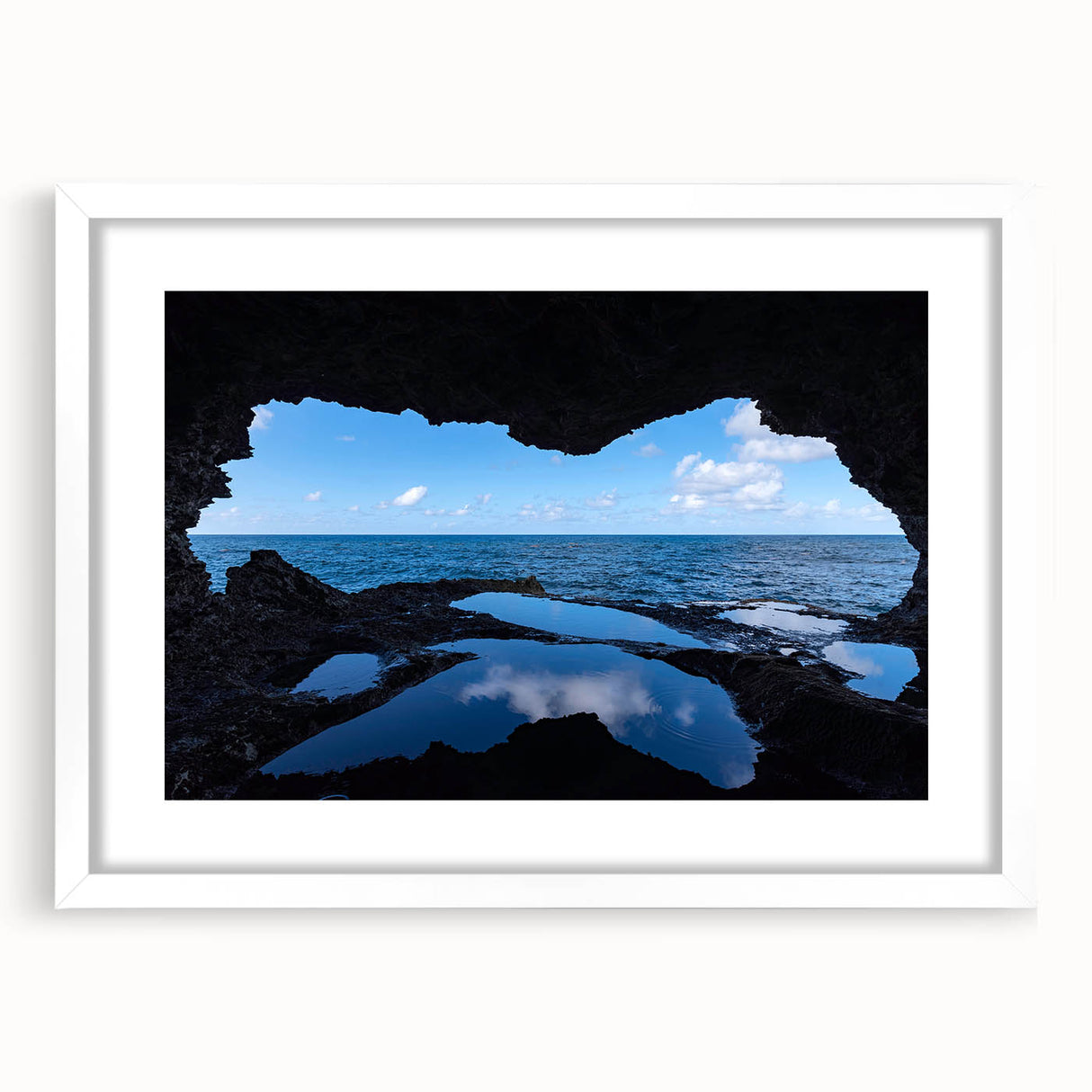 Textured abstract art print of a Caribbean seascape in muted blue and green tones, framed with a white mat.