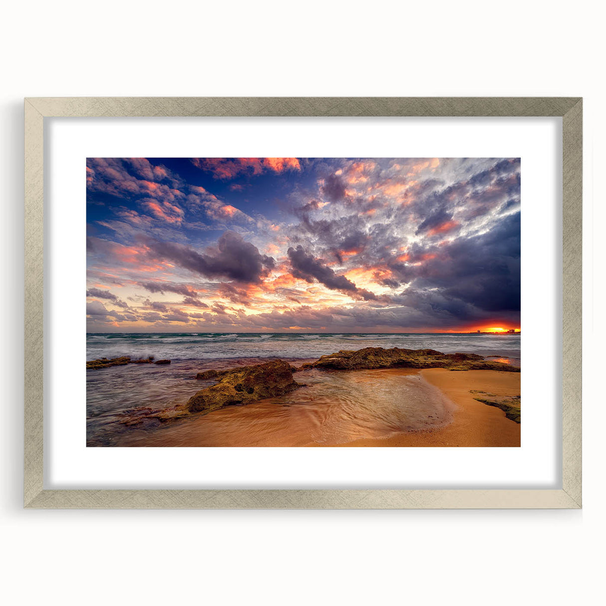 Abstract art print featuring Caribbean scenery in muted blue and green tones, framed in silver.