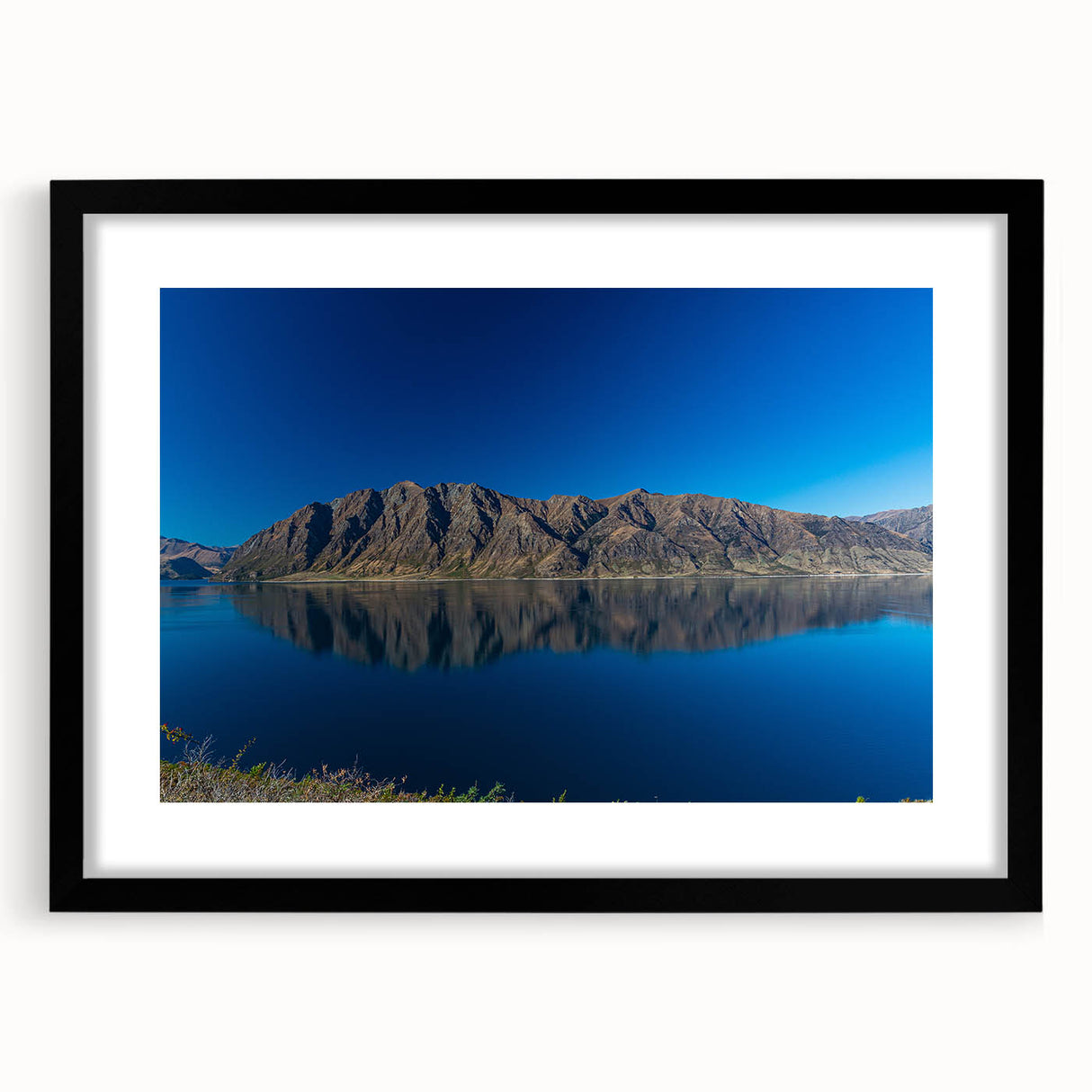 Abstract art print of Otago, New Zealand scenery in vibrant colors on a large black-framed canvas.