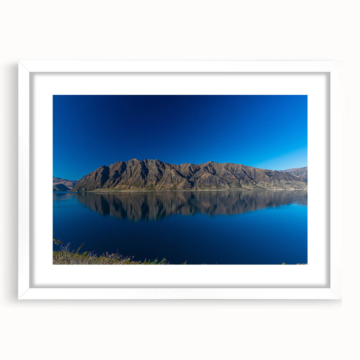 Abstract art print of Otago, New Zealand scenery in muted earth tones on a framed white mat, ideal for dining room decor.