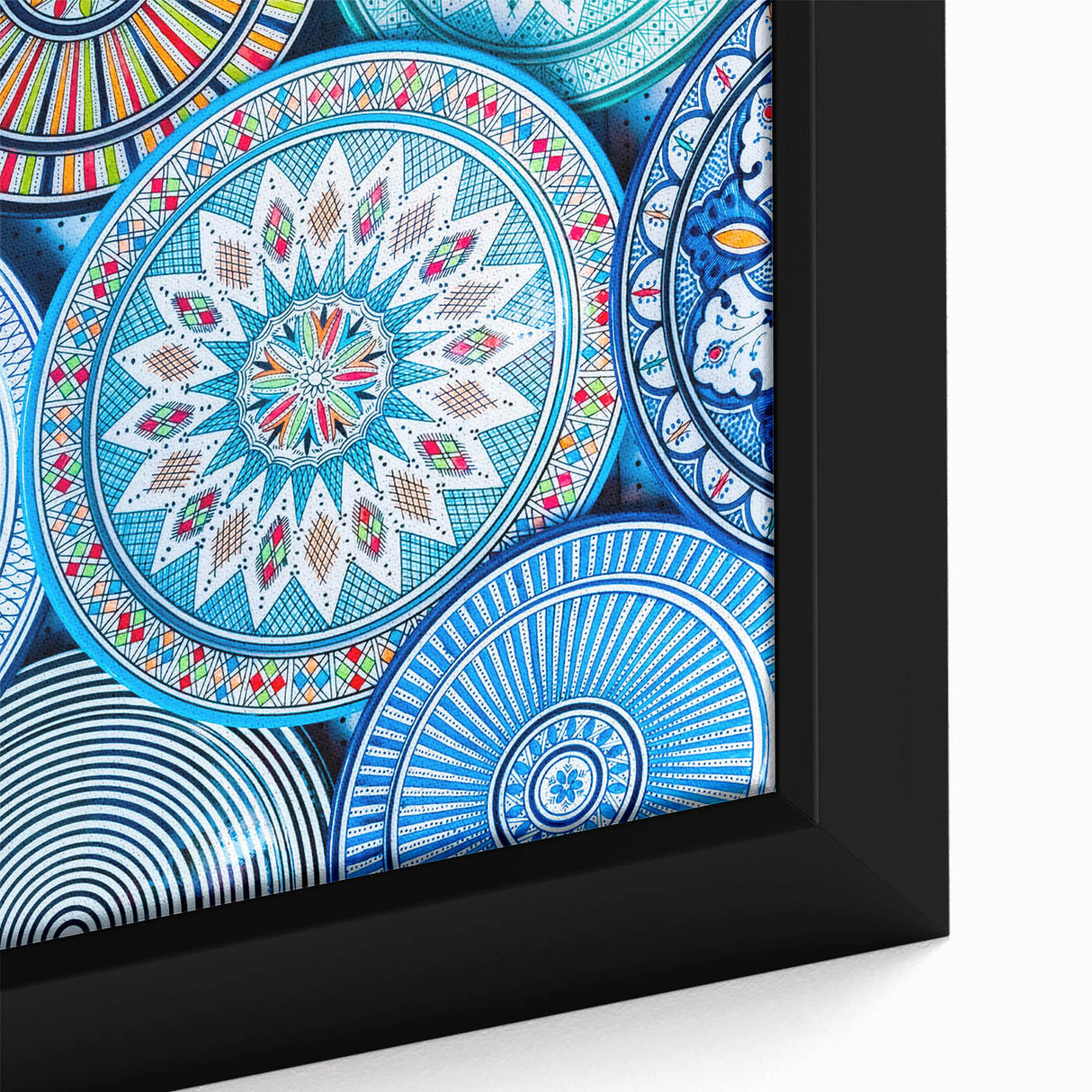 Close-up of a textured black wall art featuring a colorful Moroccan scenery on a framed canvas.