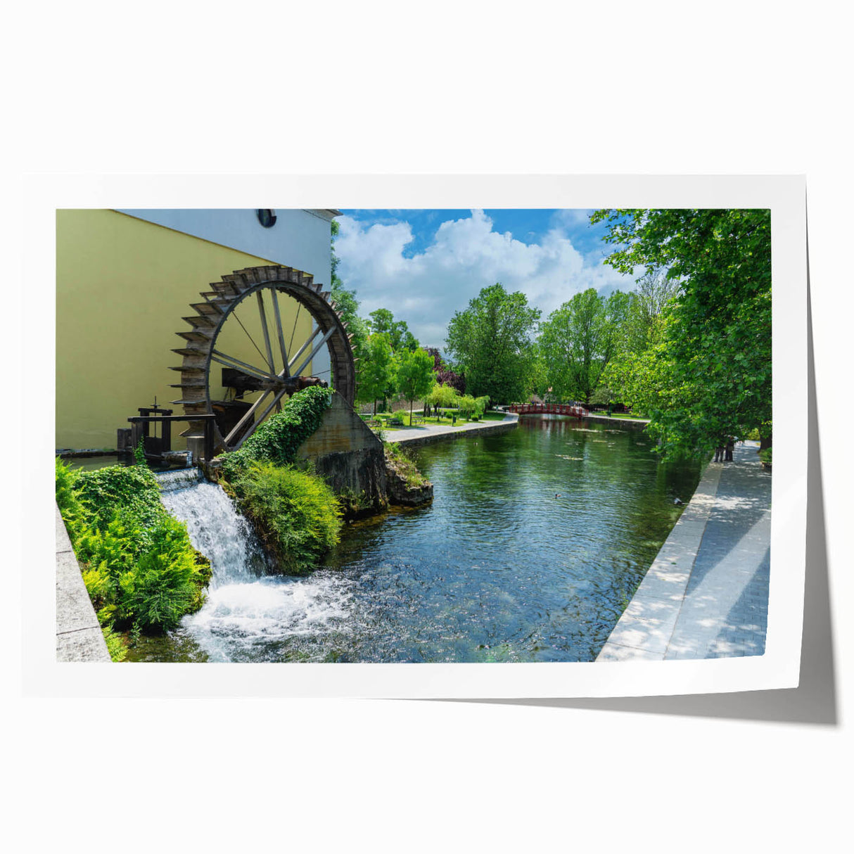Rolled print of a serene landscape featuring a traditional watermill surrounded by lush greenery, ideal for home decor, showcasing natural beauty and tranquility.