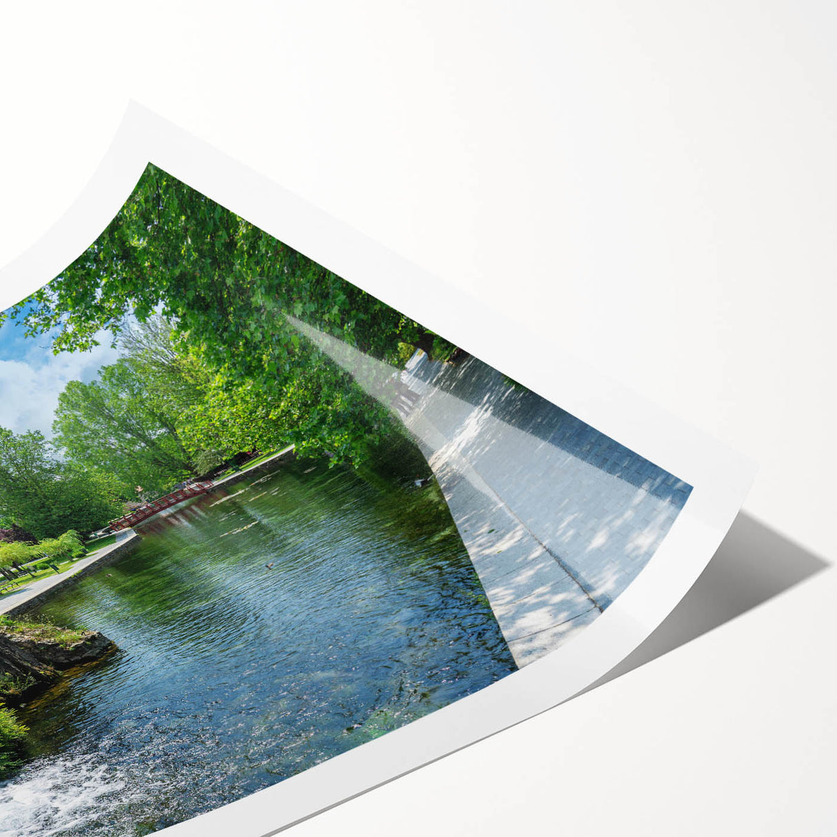 Rolled print of a serene landscape featuring a picturesque watermill surrounded by lush greenery and vibrant flowers, designed for elegant wall decor.