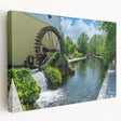 Stretched canvas wall art depicting a serene watermill landscape, showcasing vibrant greens and blues, perfect for enhancing home decor and creating a tranquil ambiance.