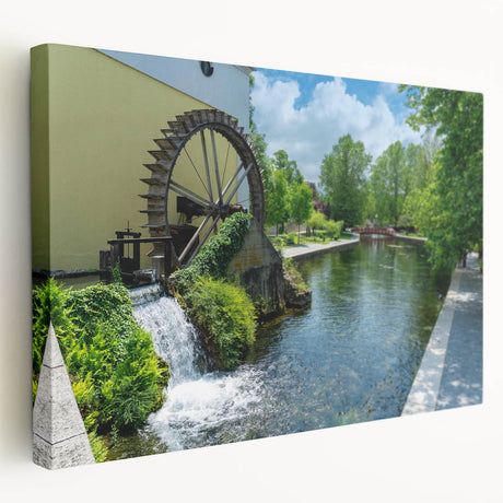 Stretched canvas wall art depicting a serene watermill landscape, showcasing vibrant greens and blues, perfect for enhancing home decor and creating a tranquil ambiance.