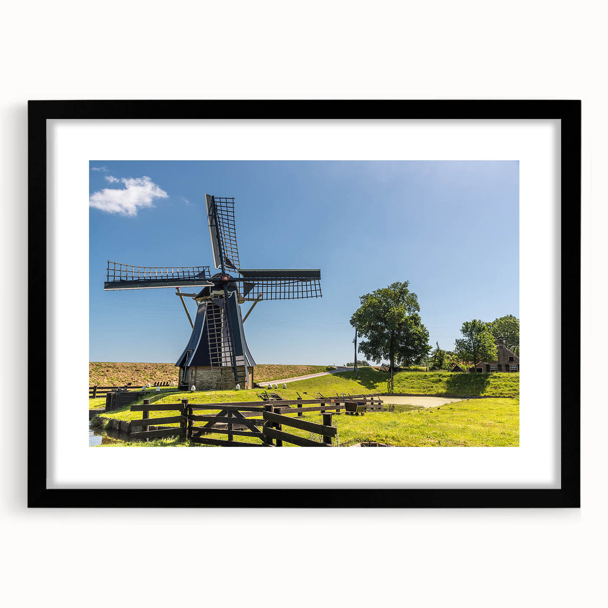 Framed wall art depicting a serene landscape with windmills, featuring a black frame and mat, ideal for home decor and enhancing interior aesthetics.