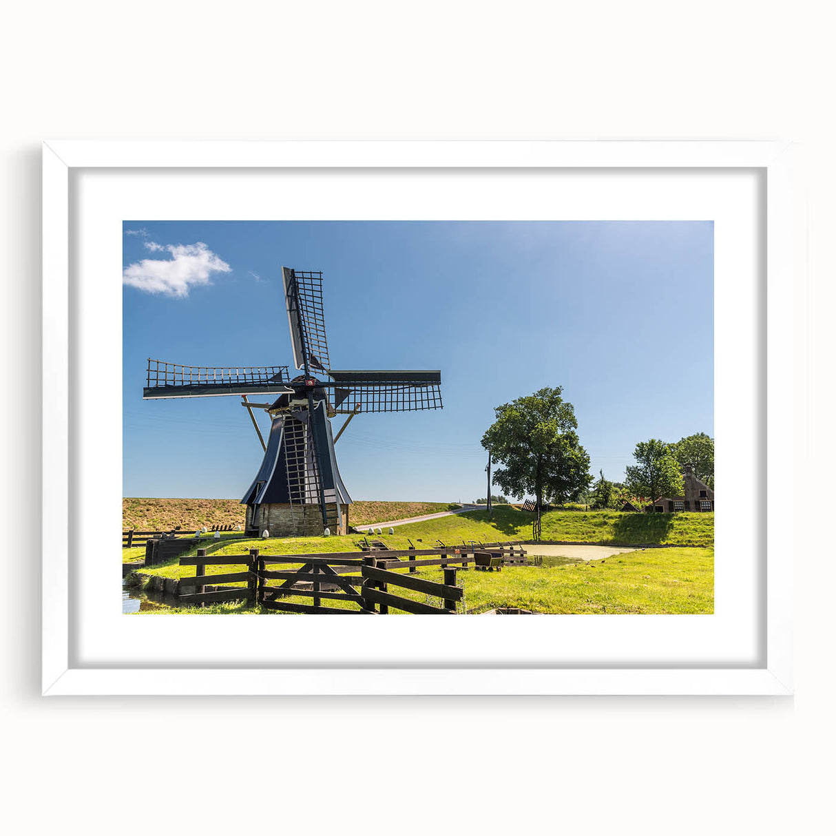 Framed wall art showcasing a serene landscape with windmills, featuring a white mat and sleek frame, perfect for home decor and enhancing interior aesthetics.