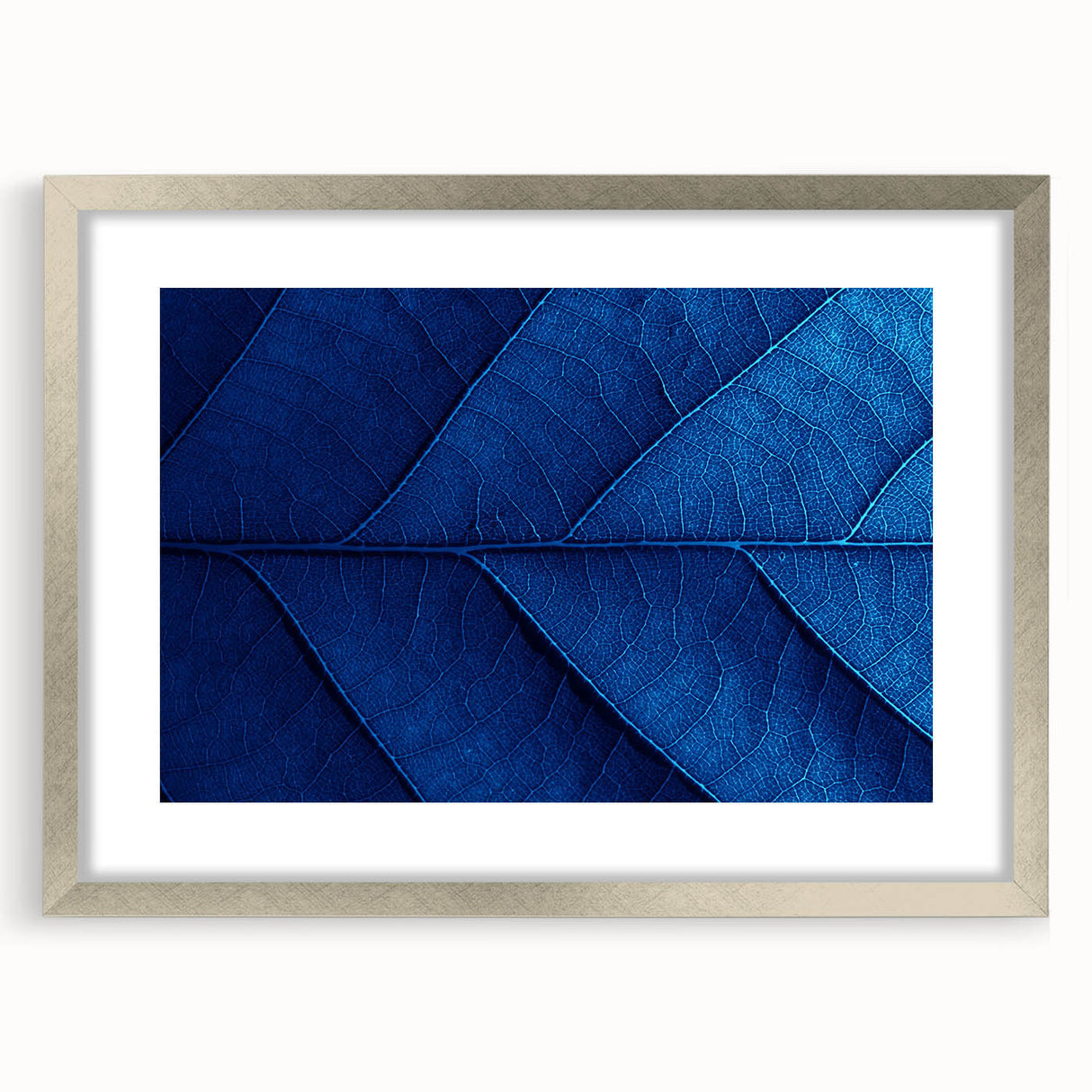 Textured abstract art print depicting floral designs in soft pastel shades, framed in silver, ideal for bedroom ambiance.