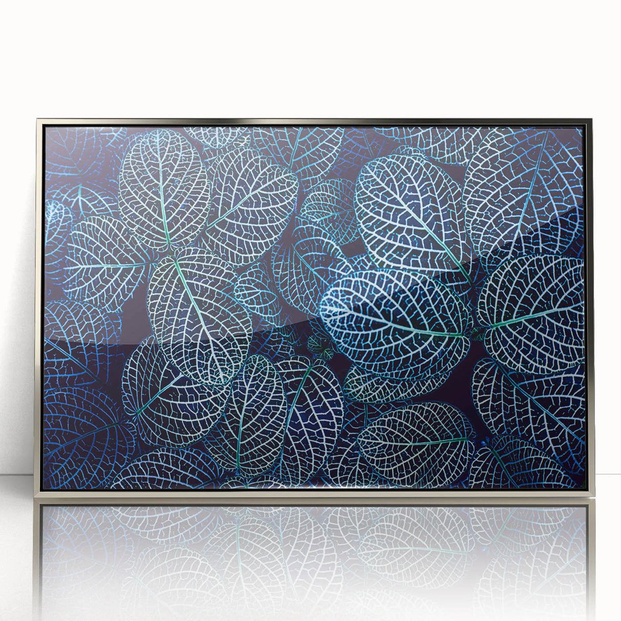 Mid-century modernist art of silver-framed acrylic depicting close-up leaves in green and yellow tones.