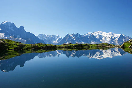 Stunning reflection of French Alps mountain range in serene blue tarn water