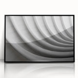 Large abstract wall art featuring swirling blue and gray tones on a framed acrylic, ideal for modern living room decor.