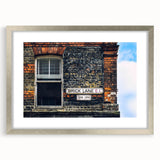 Textured abstract art print in silver frame, featuring swirling gray and white patterns, ideal for modern bedroom decor.