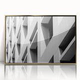 Mid-century modernist art featuring geometric shapes in gold and black on a framed acrylic print.