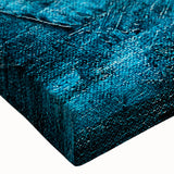 Close-up of an abstract canvas wall art piece showcasing vibrant strokes and lines in shades of blue, orange, and yellow, perfect for modern decor.