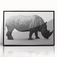 Framed wall art showcasing a striking black and white design of a rhinoceros, ideal for wildlife enthusiasts, adding a modern touch to home decor.