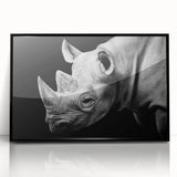 Framed wall art featuring a striking black and white rhinoceros design, showcasing intricate details and modern aesthetics, perfect for wildlife enthusiasts.