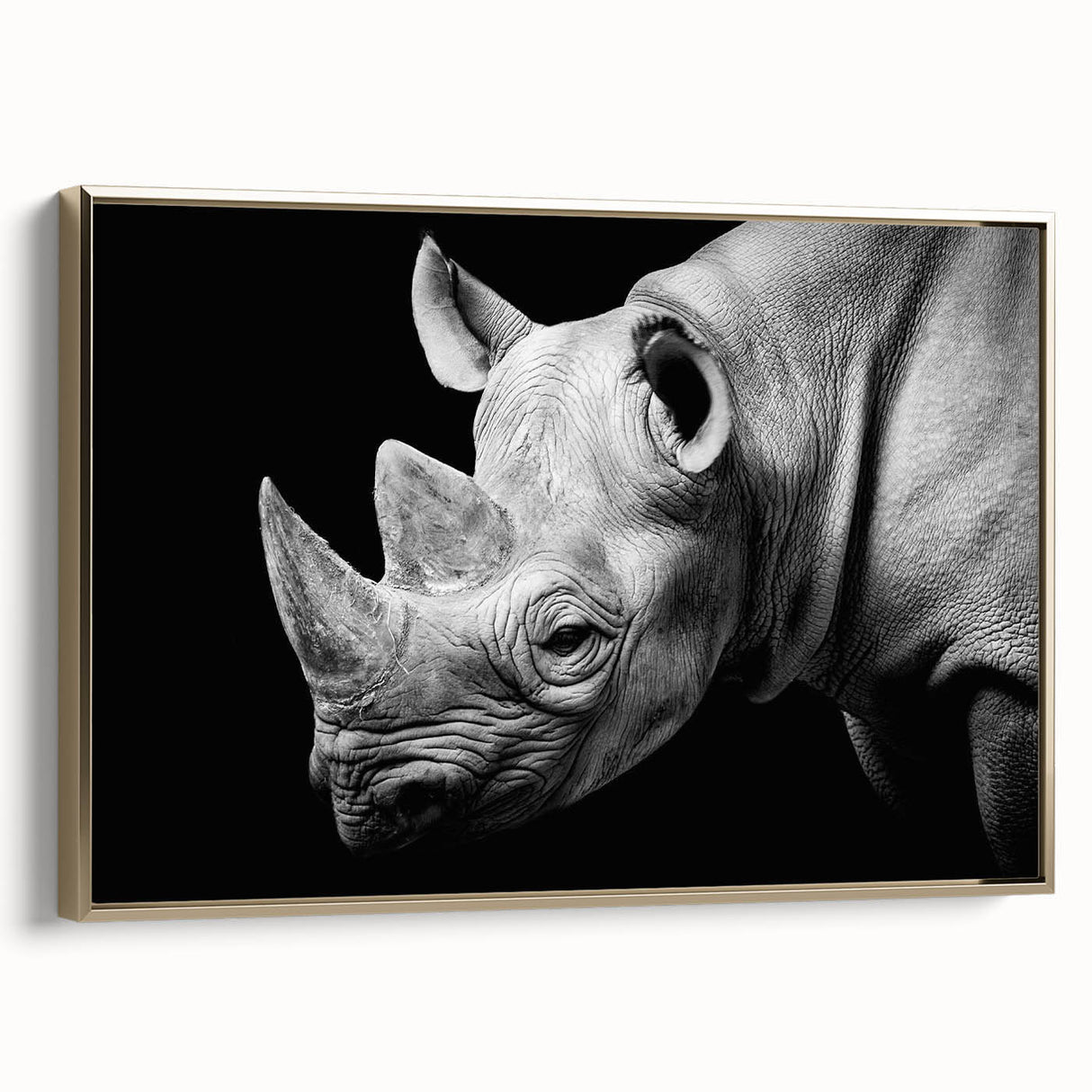 Framed wall art featuring a side view of a majestic rhinoceros in gold tones, showcasing intricate details against a neutral background, perfect for wildlife enthusiasts.