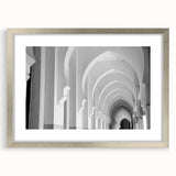 Textured art print featuring abstract arch designs in muted gray and white, framed in silver, ideal for modern bedroom decor.