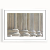 Abstract art print featuring symmetrical column designs in black and white, framed in white.