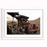 Abstract art print of a dilapidated building in muted gray and blue tones, framed with a white mat.