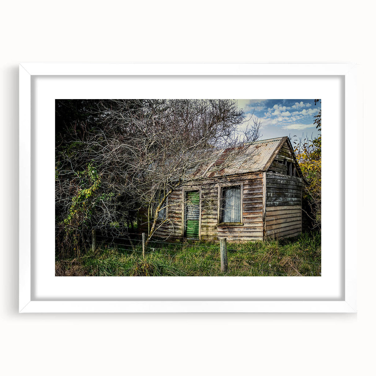 Abstract art print of a derelict building in muted gray tones on a framed white mat.