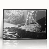 Large abstract wall art depicting a geometric fountain design in black and white tones on a framed acrylic panel.