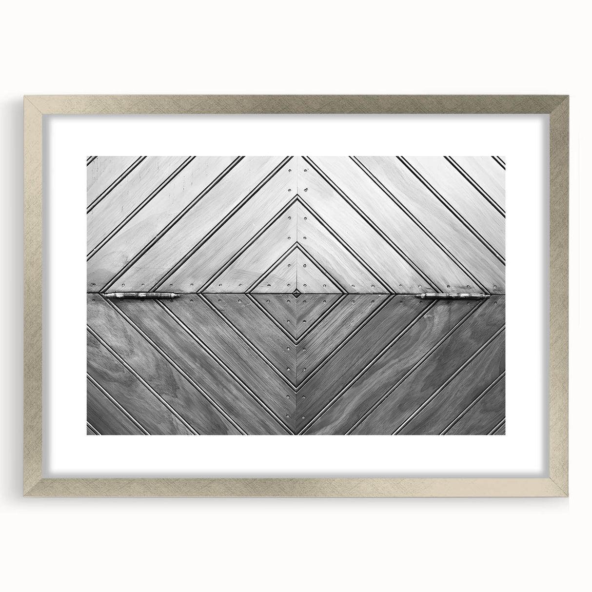 Abstract art print featuring swirling metallic silver patterns on a white background, framed in silver.