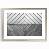 Abstract art print featuring swirling metallic silver patterns on a white background, framed in silver.