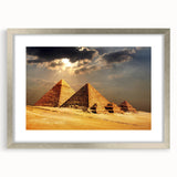 Abstract art print of geometric pyramids in muted gray, framed in silver, ideal for modern dining room decor.