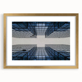 Textured art print of abstract skyscrapers in muted gray and gold, framed in gold, ideal for modern bedroom decor.