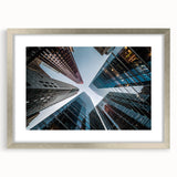 Abstract art print of a skyscraper design in silver frame with mat, using muted gray tones.