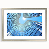 Abstract art print of skyscrapers in muted gray tones on a silver-framed mat, ideal for dining room decor.