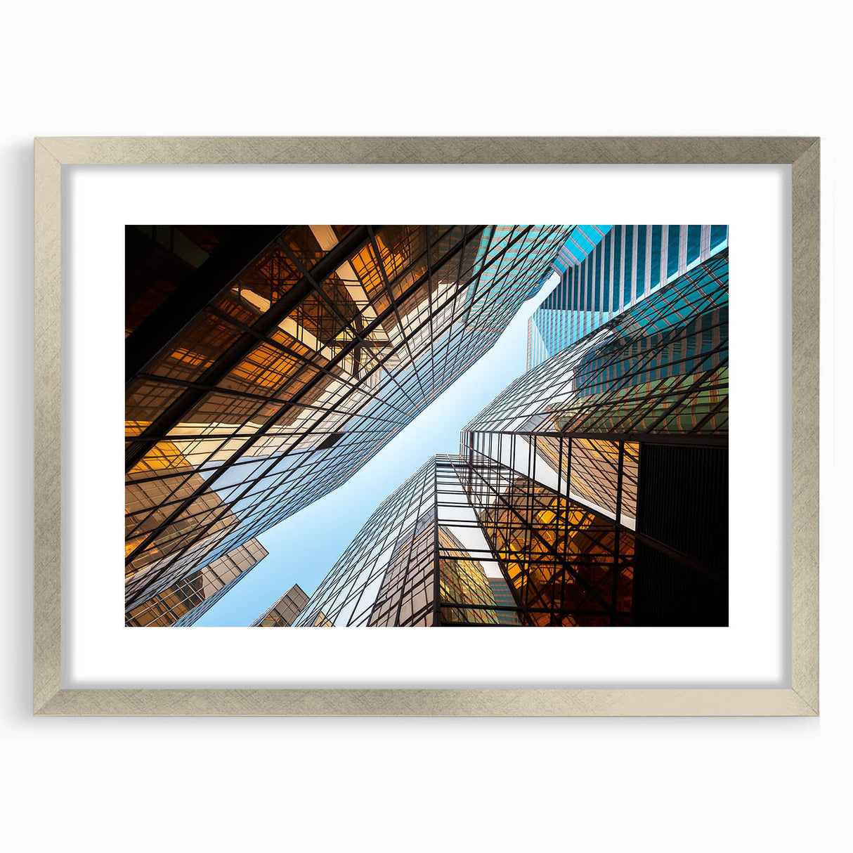 Abstract art print of geometric skyscrapers in gray and silver tones, framed with a silver mat.