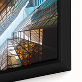 Close-up of a black wall art piece featuring a textured skyscraper design in vibrant colors on a framed canvas.