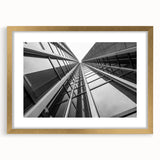 Textured abstract art print of skyscrapers in gold frame, ideal for modern bedroom ambiance.