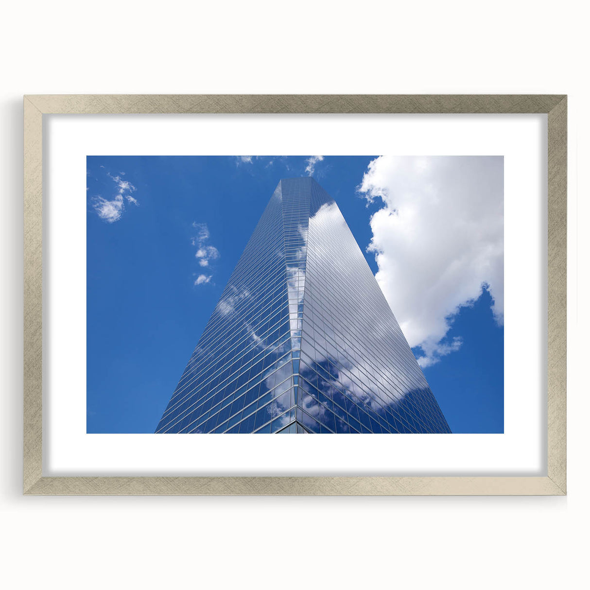 Abstract art print of skyscrapers in muted gray, framed in silver, ideal for modern bedroom or dining room decor.