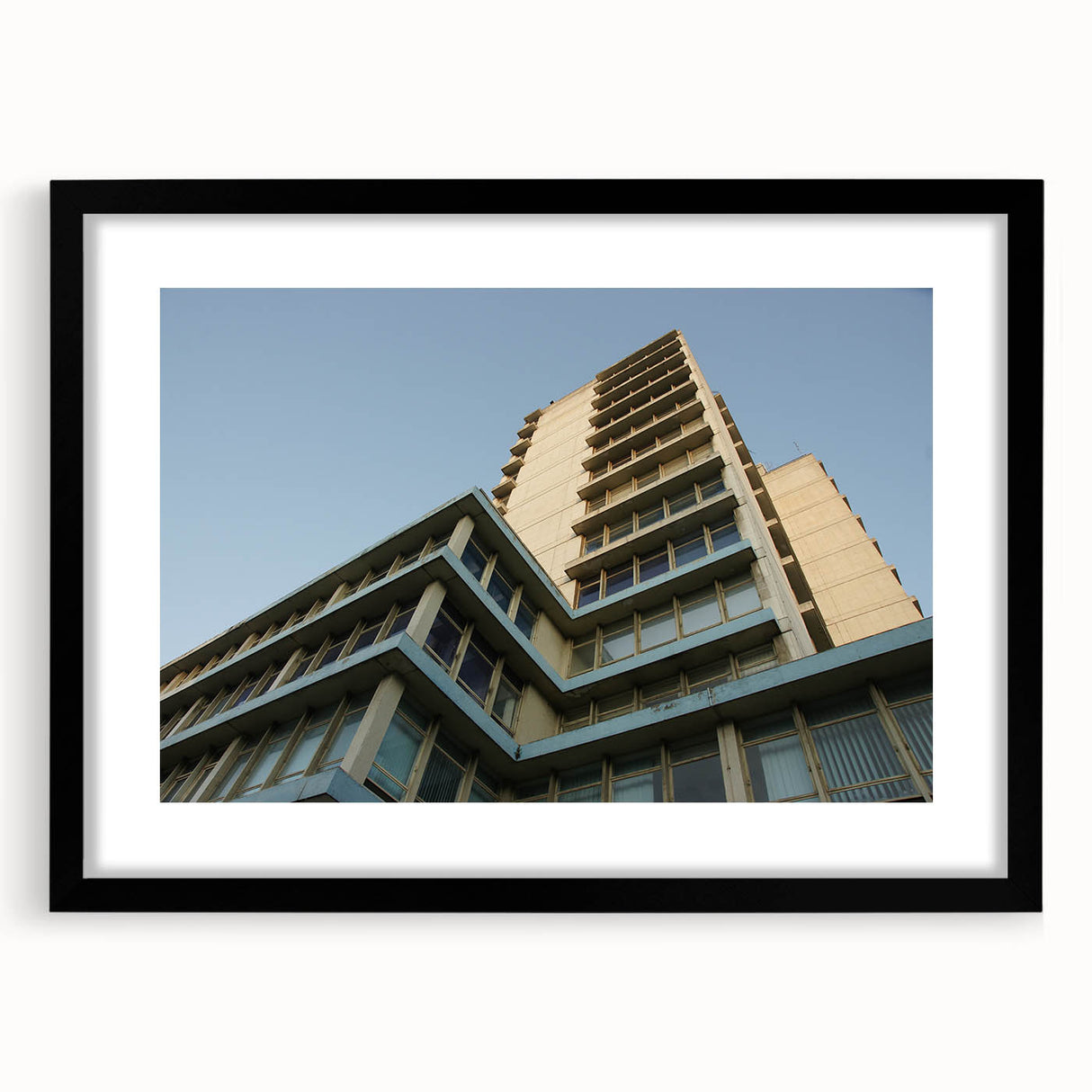 Abstract art print of skyscrapers in vibrant, colorful hues on a large framed canvas, ideal for living room decor.
