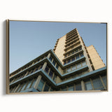 Framed canvas featuring a vintage poster of a skyscraper design in black with colorful accents, ideal for office decor.