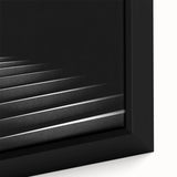 Close-up of a black wall art featuring a spiral staircase design in textured style on a framed canvas.