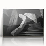 Mid-century modernist art of a spiral staircase in muted gray tones, acrylic print framed in silver.