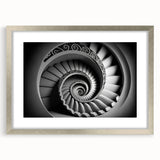 Textured abstract art print of a spiral staircase in muted gray, framed in silver, ideal for modern bedroom decor.