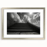 Textured art print of an abstract staircase in muted gray, framed in silver, ideal for modern bedroom decor.