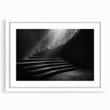Abstract art print of a spiral staircase in monochrome, framed in white, suitable for bedroom or dining room decor.