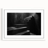 Abstract art print of a spiral staircase in monochrome, framed in white, suitable for dining room or bedroom decor.