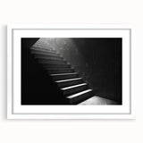 Abstract art print of a spiral staircase in grayscale, framed with a white mat, suitable for bedroom or dining room decor.