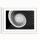 Abstract art print of a spiraling staircase in monochrome, framed in white, suitable for dining room or bedroom decor.
