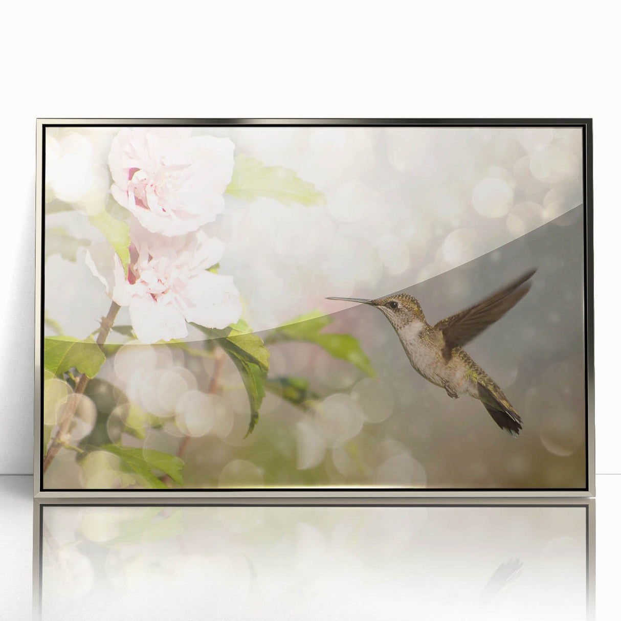 Framed wall art featuring a detailed hummingbird design in vibrant colors, showcased in a sleek silver frame, perfect for enhancing modern decor.