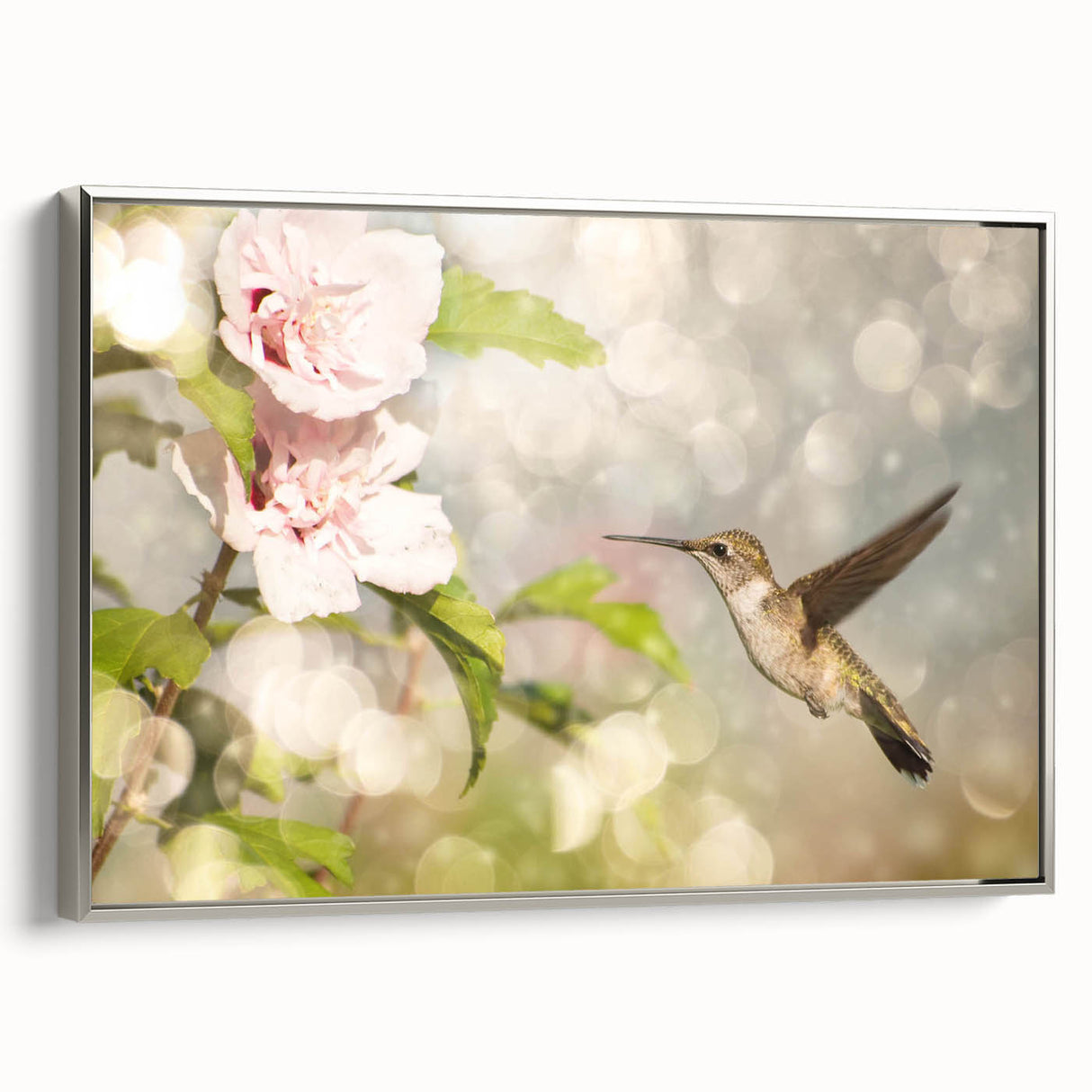 Framed wall art featuring a vibrant hummingbird design on a textured canvas with a sleek silver frame, perfect for adding a touch of nature to any decor.